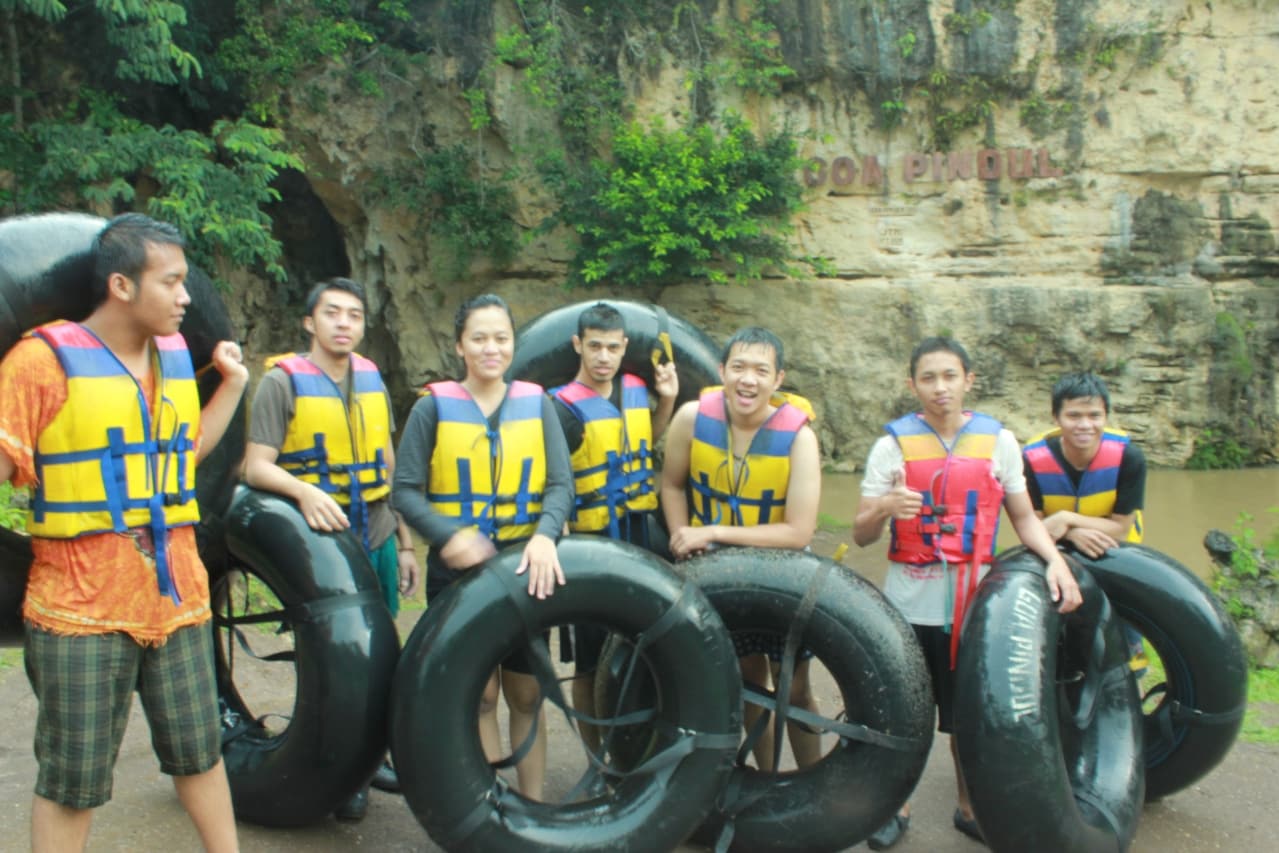 Visitors in life jackets holding inner tubes at Pindul Cave
