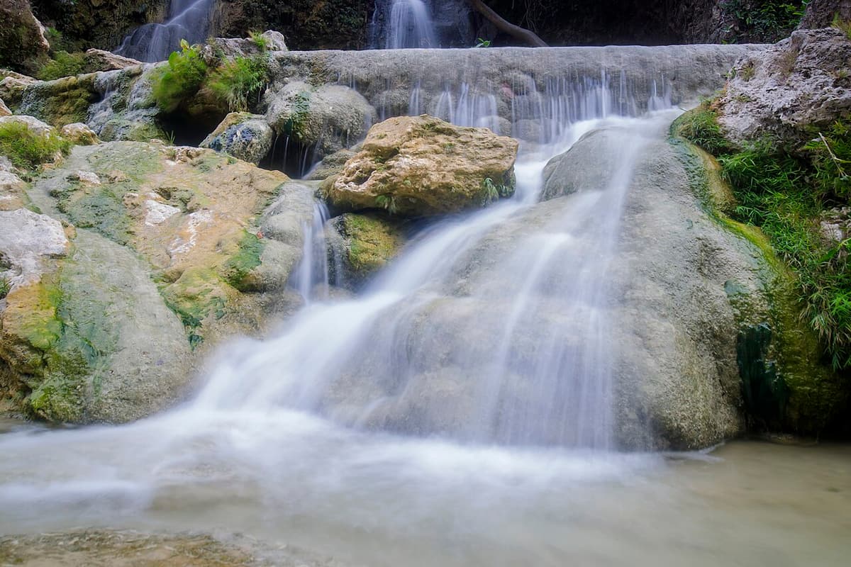 Sri Gethuk waterfall spilling over limestone ledges into the Oyo River